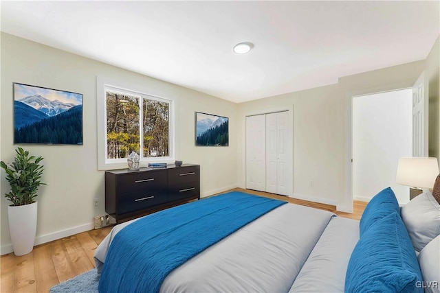 bedroom with light hardwood / wood-style floors and a closet