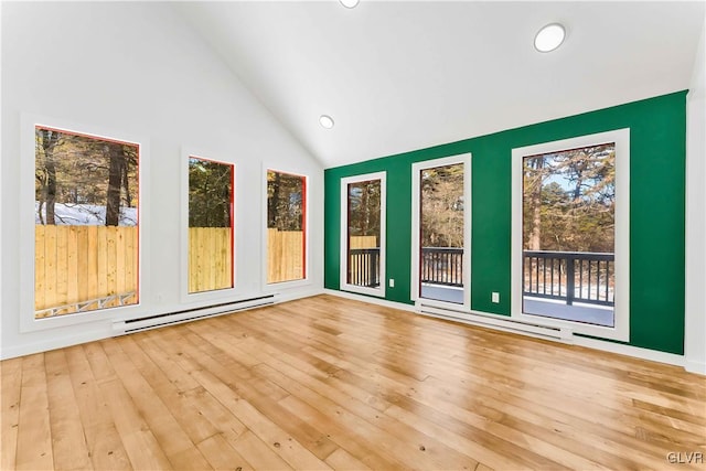 unfurnished sunroom with baseboard heating and vaulted ceiling