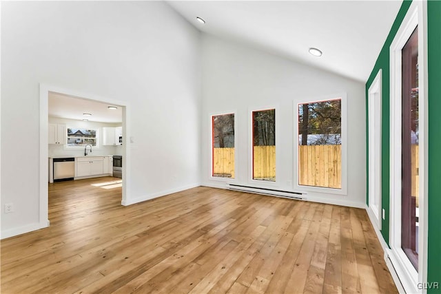 interior space featuring a baseboard radiator, high vaulted ceiling, sink, and light wood-type flooring