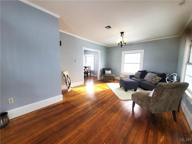 living room featuring ornamental molding, hardwood / wood-style floors, and an inviting chandelier