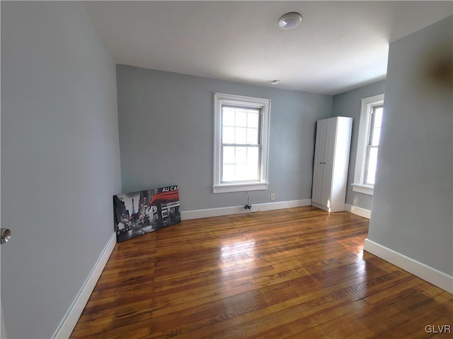 empty room featuring dark wood-type flooring and a wealth of natural light