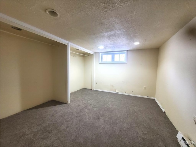 interior space featuring a textured ceiling and dark colored carpet