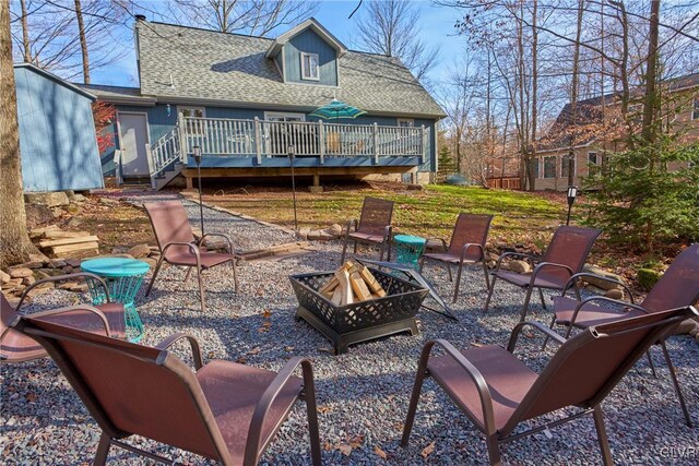 view of patio with a wooden deck and a fire pit