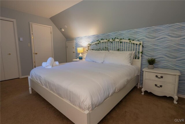 bedroom with lofted ceiling and dark colored carpet