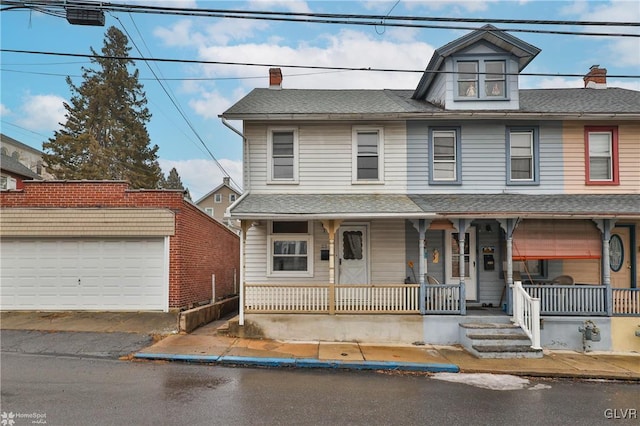 view of front of property featuring an outbuilding, a porch, and a garage