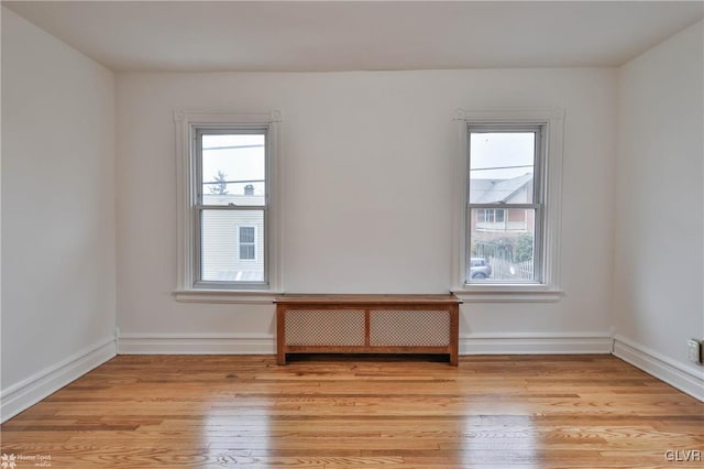 spare room with radiator and light wood-type flooring