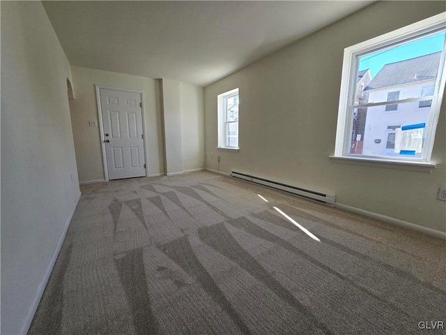 unfurnished room with a baseboard heating unit and light carpet