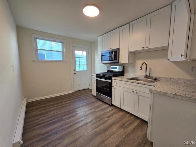 kitchen featuring sink, baseboard heating, white cabinetry, stainless steel appliances, and dark hardwood / wood-style flooring