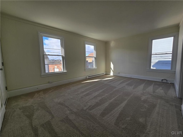 spare room featuring baseboard heating and dark carpet