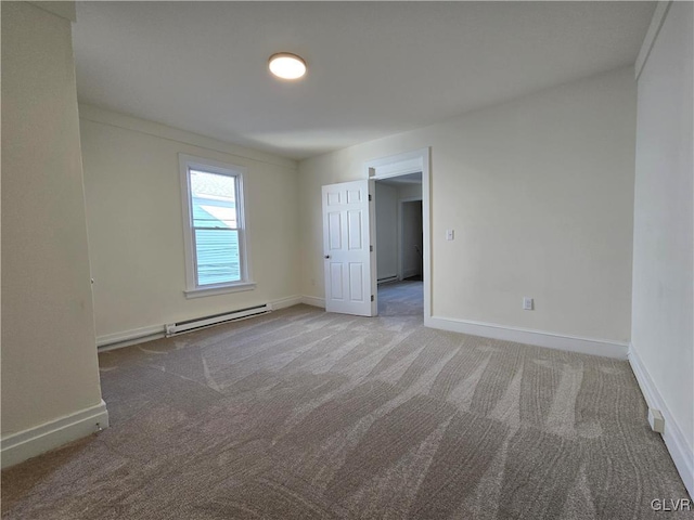 carpeted spare room with a baseboard radiator