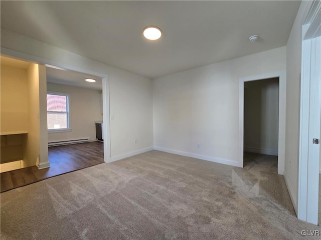 spare room with carpet floors and a baseboard radiator