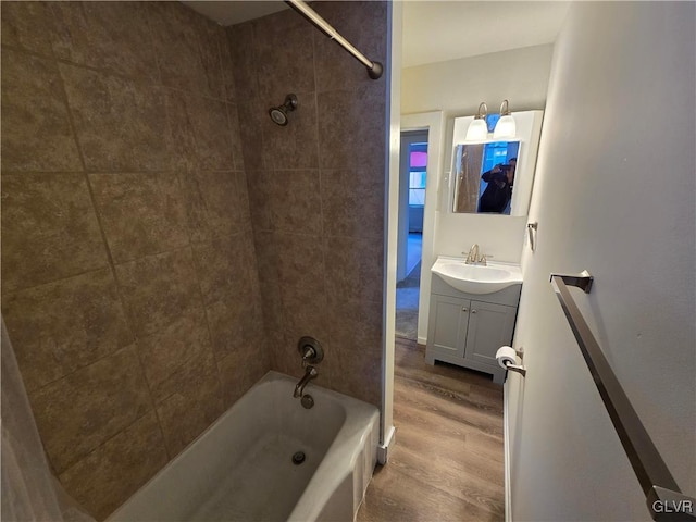 bathroom with tiled shower / bath, wood-type flooring, and vanity