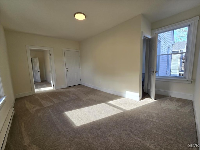 carpeted empty room featuring baseboard heating