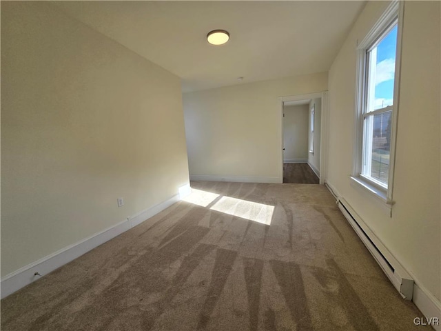 carpeted spare room featuring a baseboard radiator and plenty of natural light