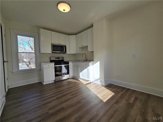 kitchen with white cabinetry, appliances with stainless steel finishes, dark hardwood / wood-style flooring, and sink