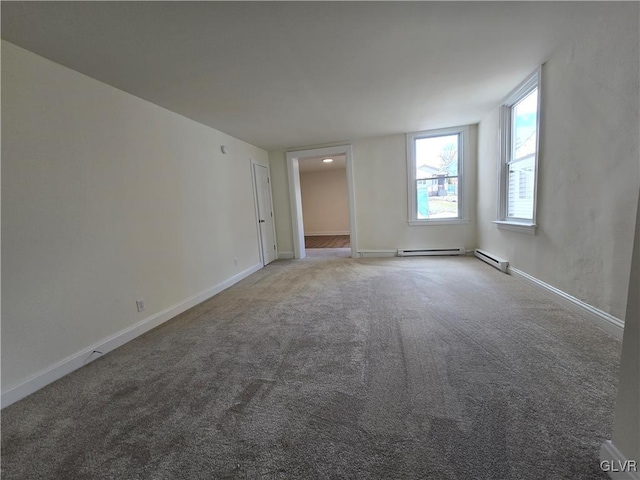 carpeted spare room featuring a baseboard heating unit