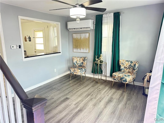 living area featuring ceiling fan, hardwood / wood-style flooring, a wealth of natural light, and a wall mounted AC