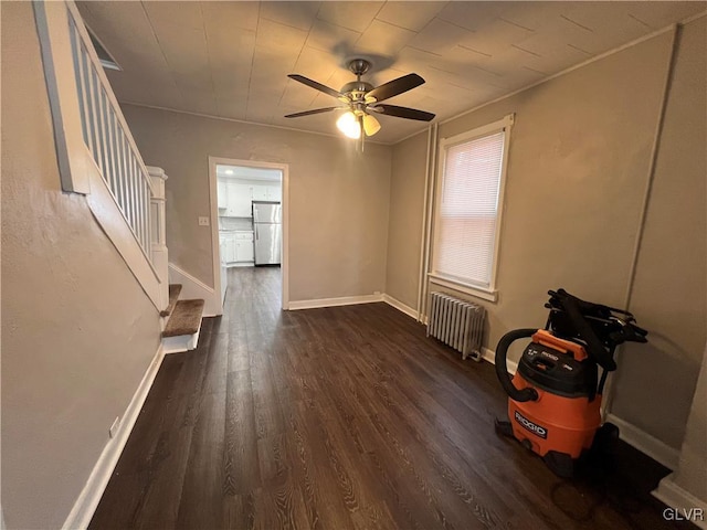 spare room with dark wood-type flooring, radiator heating unit, and ceiling fan