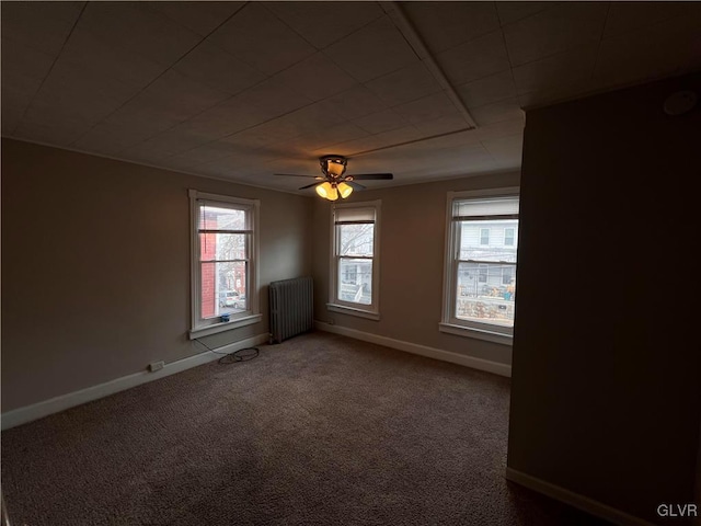 unfurnished room with carpet floors, radiator heating unit, and ceiling fan