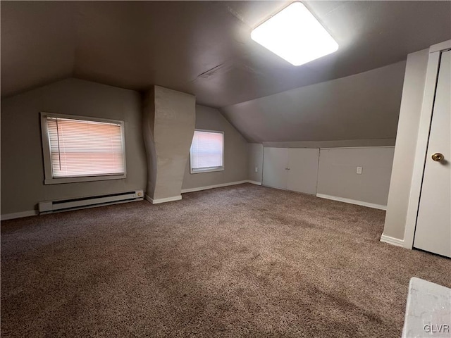 additional living space featuring baseboard heating, vaulted ceiling, and carpet floors