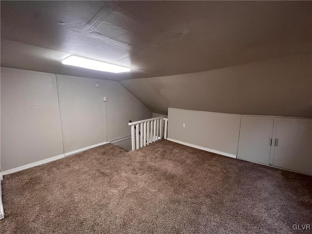 bonus room with vaulted ceiling and carpet flooring