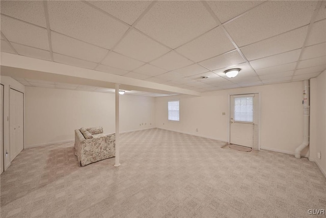 basement featuring light carpet and a drop ceiling