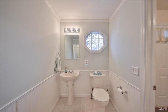 bathroom with ornamental molding, toilet, and tile patterned flooring