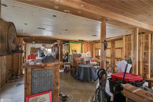 miscellaneous room with concrete flooring, wooden walls, and wood ceiling