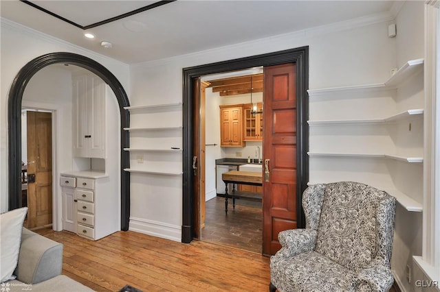 sitting room featuring ornamental molding and light hardwood / wood-style flooring