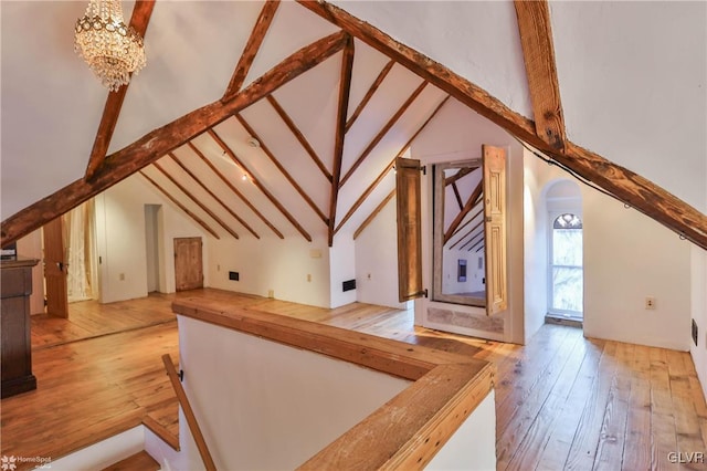 bonus room with light wood-type flooring, a chandelier, and vaulted ceiling with beams