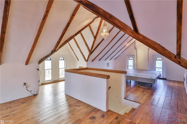 bonus room featuring light wood-type flooring and vaulted ceiling with beams