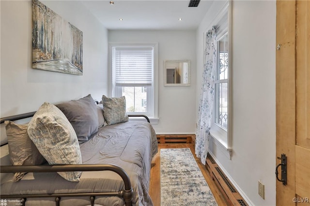 bedroom featuring hardwood / wood-style flooring and a baseboard radiator