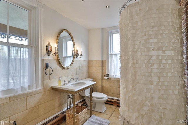 bathroom featuring sink, tile walls, toilet, tile patterned floors, and baseboard heating