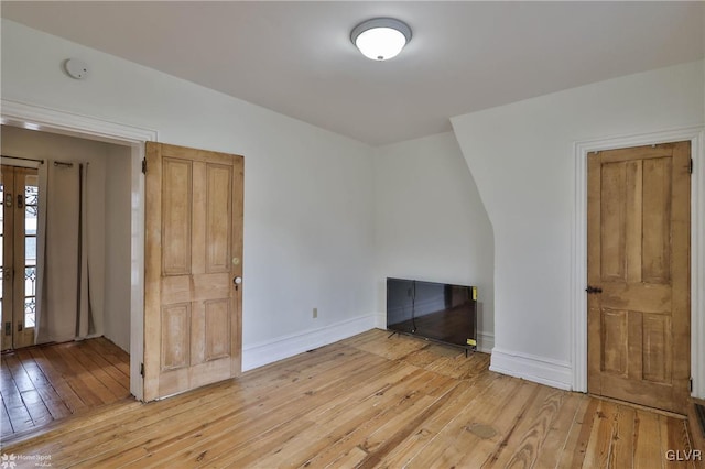 unfurnished living room featuring french doors and light hardwood / wood-style flooring