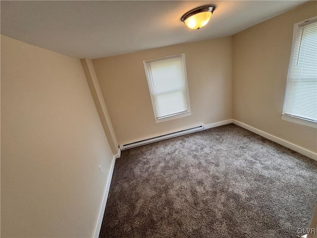 carpeted empty room with a baseboard heating unit