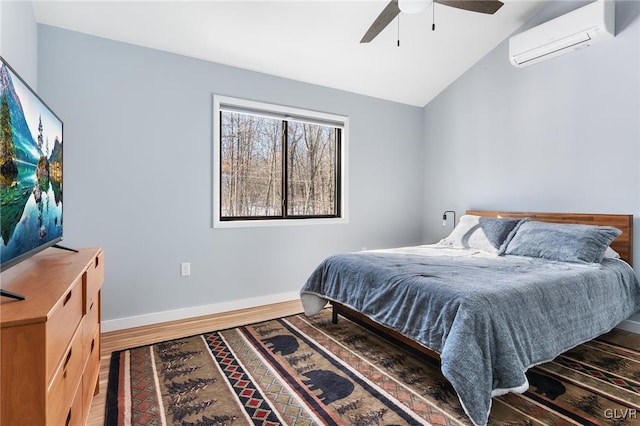 bedroom featuring hardwood / wood-style floors, lofted ceiling, a wall mounted air conditioner, and ceiling fan