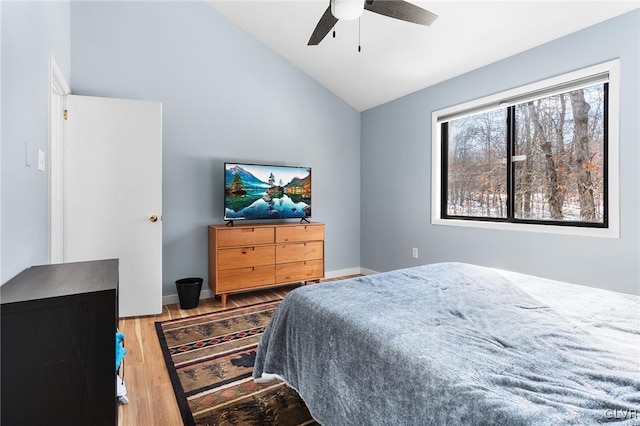 bedroom with hardwood / wood-style flooring, vaulted ceiling, and ceiling fan