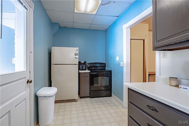 kitchen with gray cabinetry, black / electric stove, a paneled ceiling, and white fridge