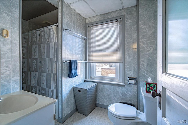 bathroom with toilet, a shower with shower curtain, and tile walls