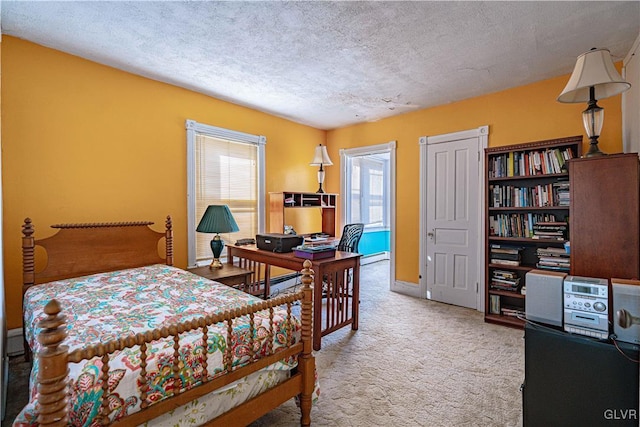 carpeted bedroom featuring a baseboard heating unit and a textured ceiling