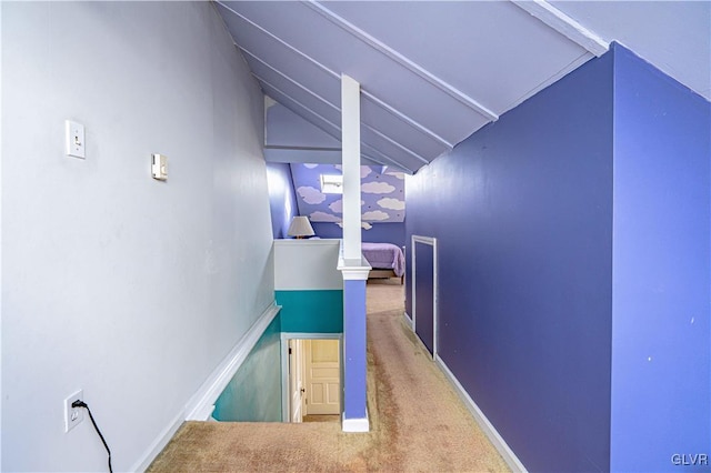 hallway with carpet flooring and vaulted ceiling