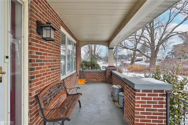 snow covered patio featuring a porch