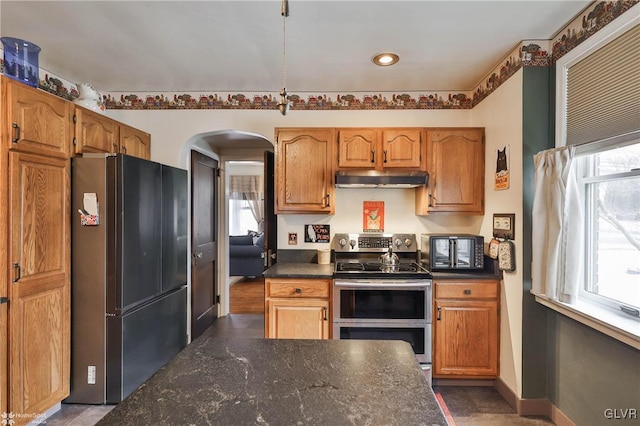 kitchen with double oven range, plenty of natural light, and black refrigerator