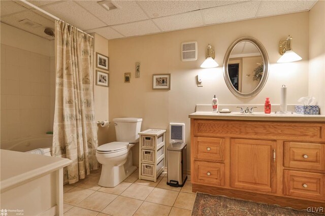 full bathroom featuring a paneled ceiling, shower / tub combo, vanity, tile patterned floors, and toilet