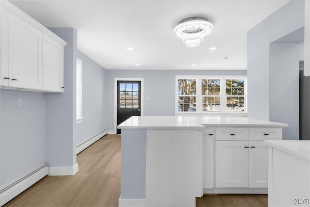 kitchen with a baseboard heating unit, light hardwood / wood-style flooring, and white cabinets