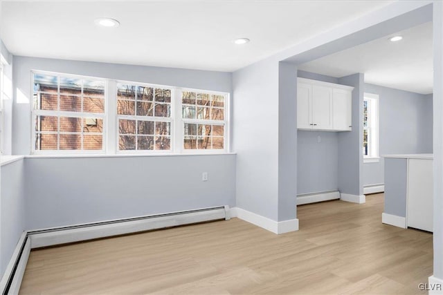 empty room with light wood-type flooring and baseboard heating