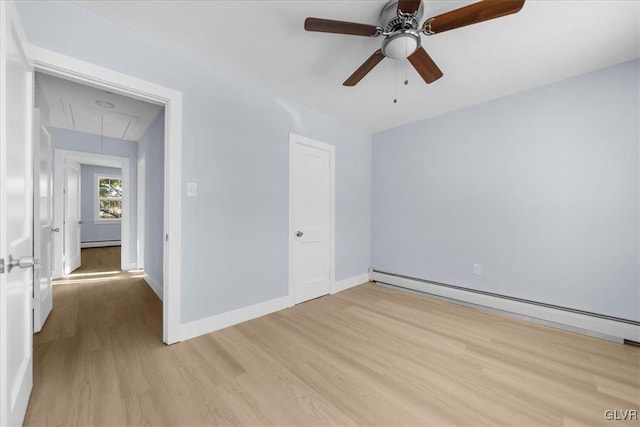 empty room featuring ceiling fan, light wood-type flooring, and baseboard heating