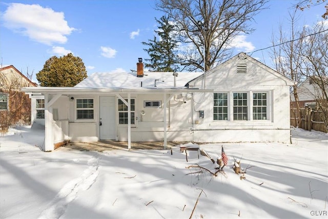 view of snow covered back of property