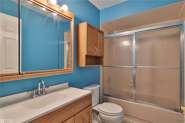 full bathroom featuring vanity, enclosed tub / shower combo, and toilet