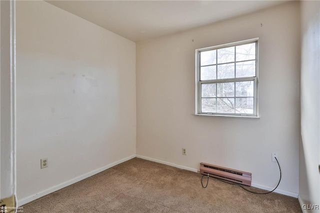 spare room featuring light colored carpet and a baseboard radiator